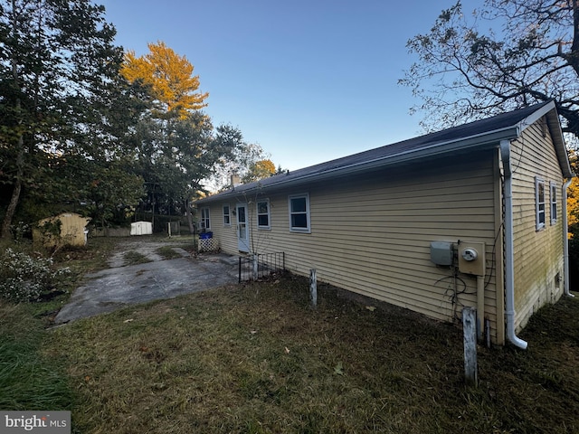 view of side of home with a patio and a yard