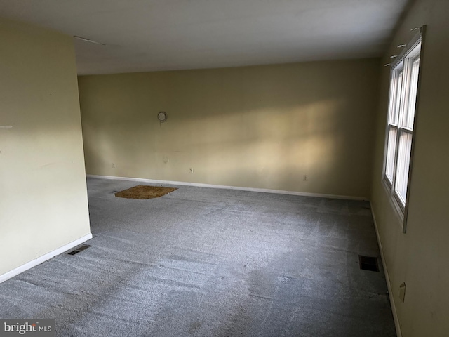 spare room with dark carpet