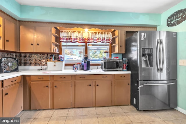 kitchen featuring decorative backsplash, appliances with stainless steel finishes, and light tile patterned floors