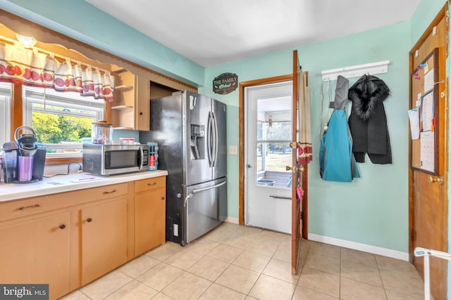 kitchen with stainless steel appliances, open shelves, light countertops, light tile patterned floors, and baseboards