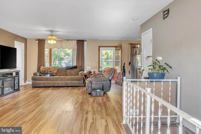 living room with a ceiling fan and light wood-style floors