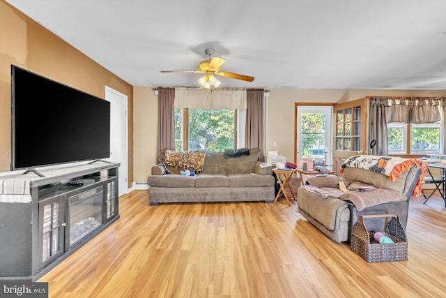 living room with light hardwood / wood-style flooring and ceiling fan