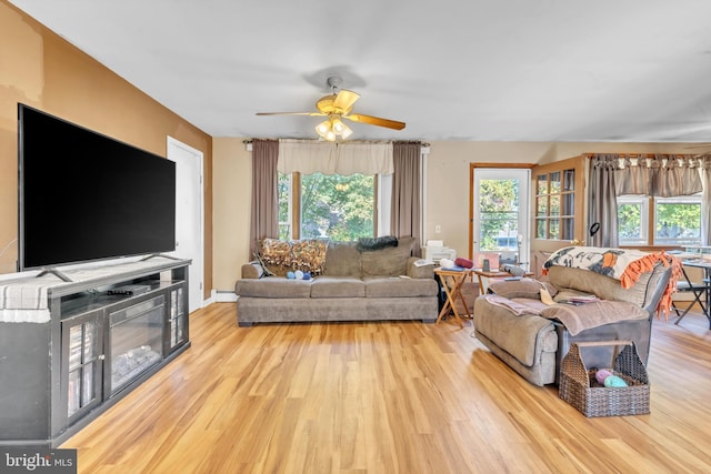 living room with a ceiling fan, a wealth of natural light, and wood finished floors