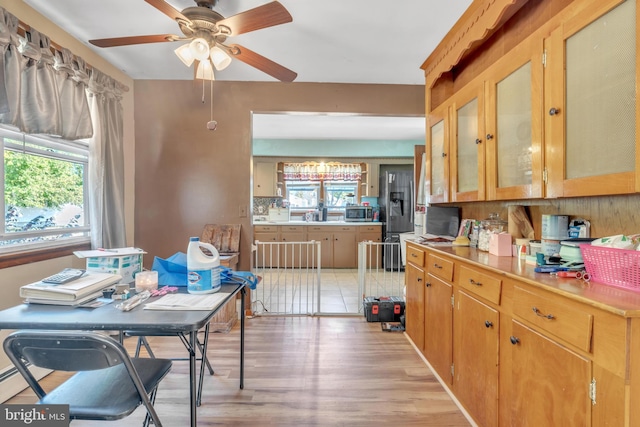 kitchen with light countertops, light wood-type flooring, stainless steel appliances, and ceiling fan