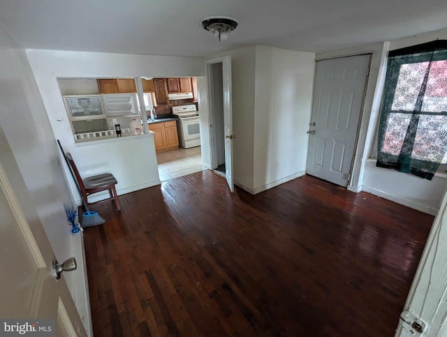 interior space with white electric range oven and hardwood / wood-style floors