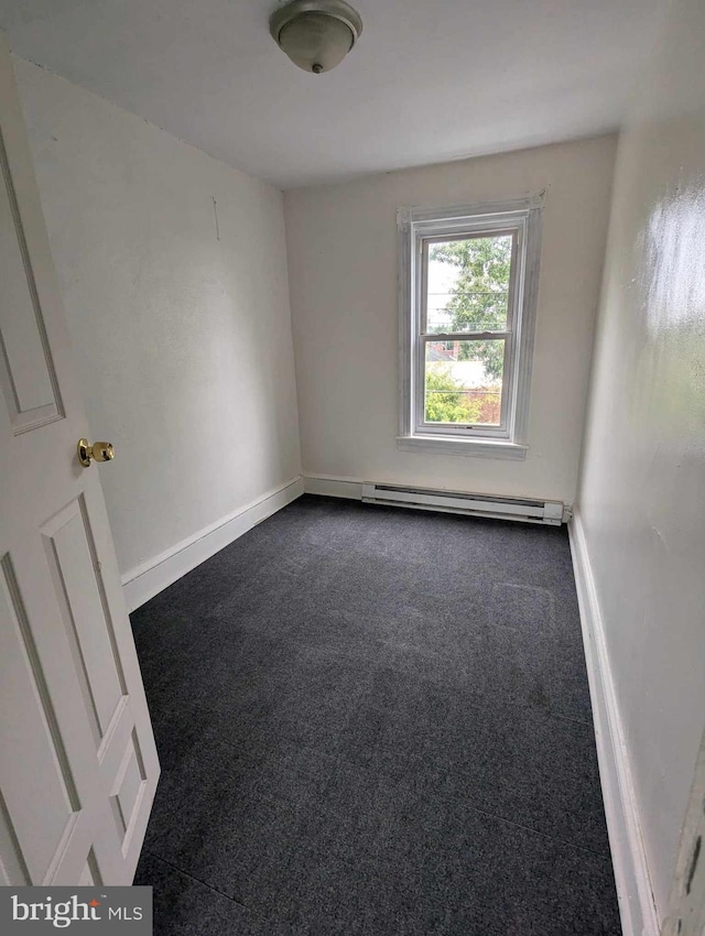 unfurnished room featuring a baseboard radiator and dark colored carpet