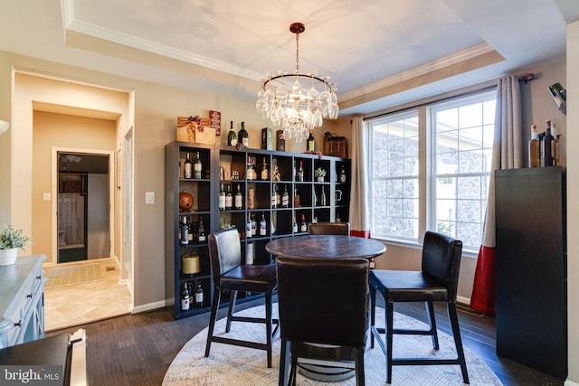 dining area featuring dark hardwood / wood-style floors, a tray ceiling, and crown molding