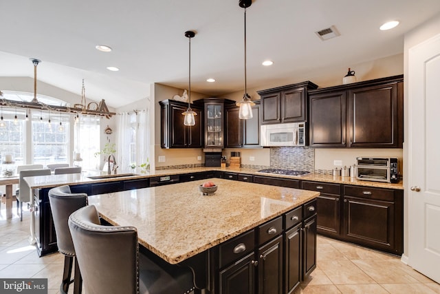 kitchen featuring sink, stainless steel appliances, a kitchen breakfast bar, and a center island