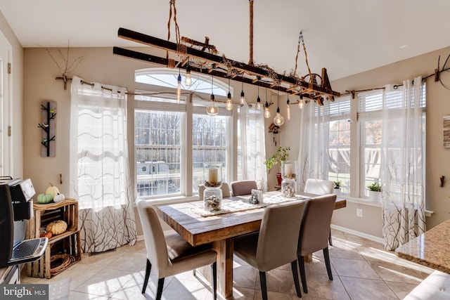 dining room featuring vaulted ceiling and light tile patterned flooring