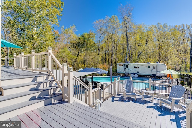 deck featuring a fenced in pool