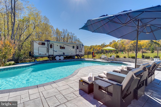 view of swimming pool with an outdoor structure and a patio area