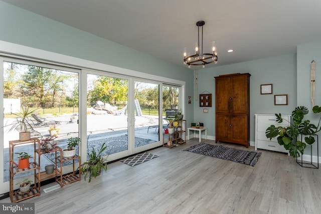 entryway with light hardwood / wood-style floors and a chandelier