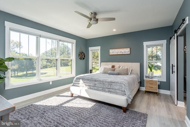 bedroom with a barn door and multiple windows