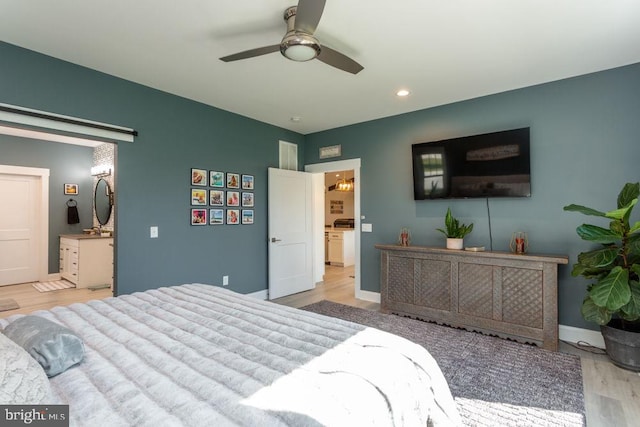 bedroom with light hardwood / wood-style floors, ensuite bath, and ceiling fan