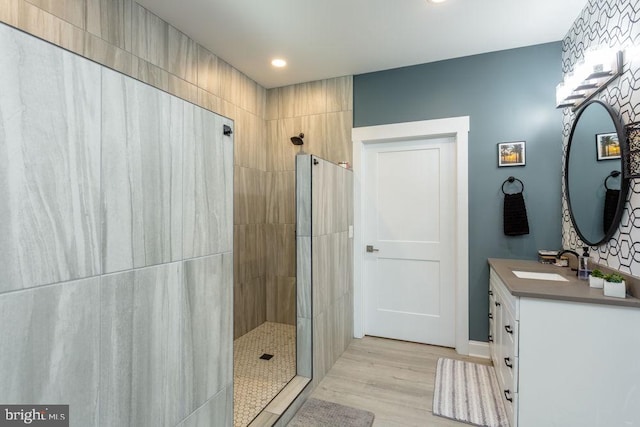 bathroom featuring vanity, hardwood / wood-style flooring, and tiled shower