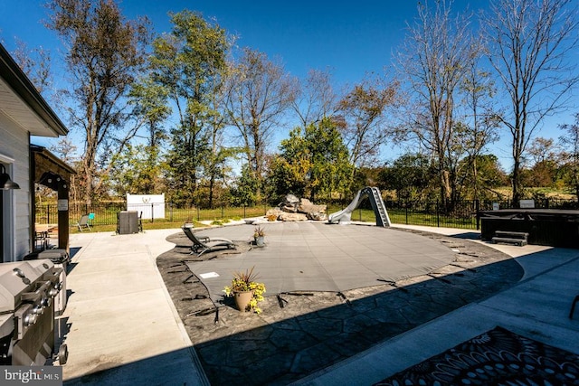 view of patio / terrace featuring a pool with hot tub