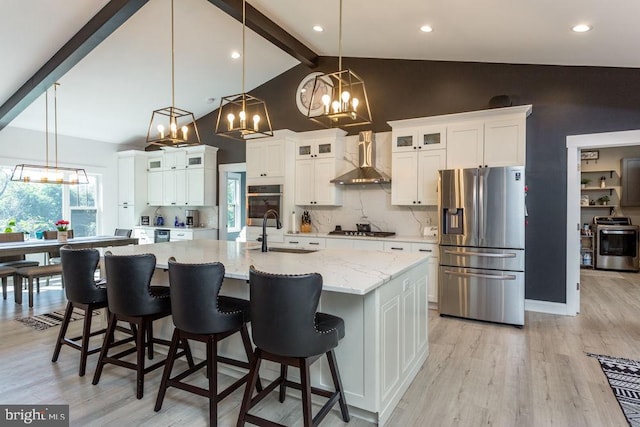 kitchen featuring sink, a large island, stainless steel appliances, wall chimney exhaust hood, and pendant lighting