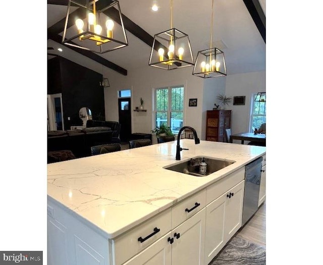 kitchen with a center island with sink, sink, decorative light fixtures, stainless steel dishwasher, and white cabinets