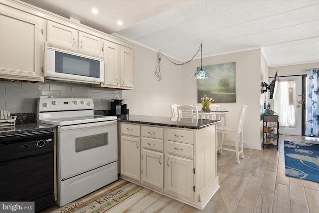 kitchen featuring decorative backsplash, kitchen peninsula, pendant lighting, light wood-type flooring, and white appliances