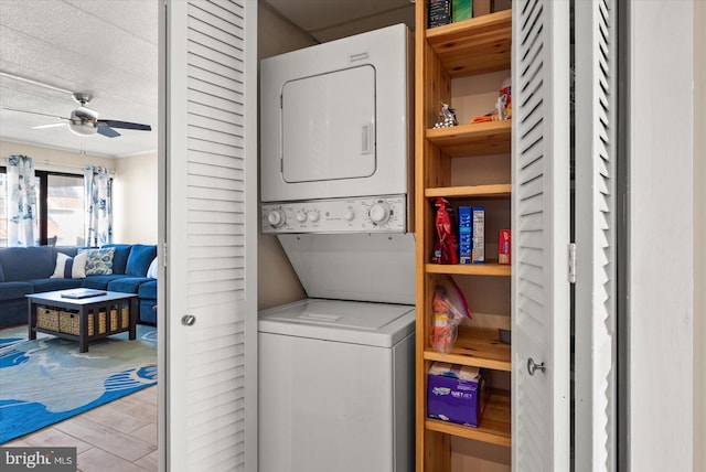 laundry room featuring stacked washer / dryer, light hardwood / wood-style flooring, and ceiling fan