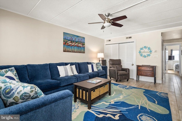 living room with ceiling fan and light hardwood / wood-style flooring