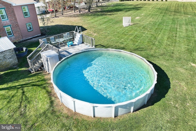 view of swimming pool with a wooden deck and a yard