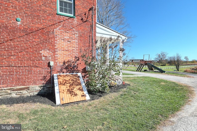 view of property exterior featuring a playground and a lawn