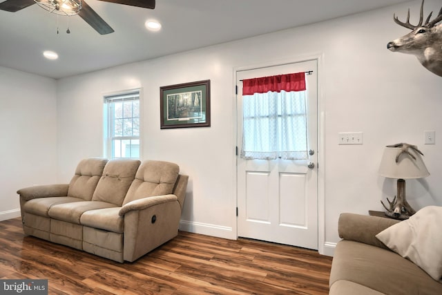 living room with dark hardwood / wood-style floors and ceiling fan