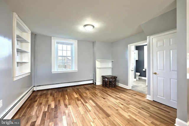 unfurnished living room with light wood-type flooring and a baseboard radiator