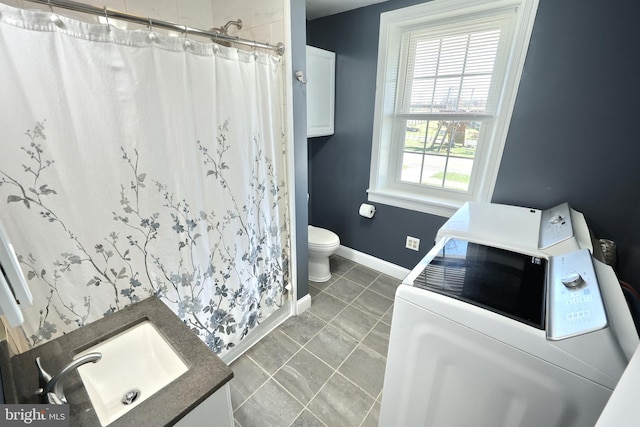 bathroom featuring tile patterned flooring, a shower with shower curtain, vanity, washer and dryer, and toilet