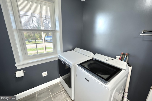 clothes washing area with a healthy amount of sunlight, tile patterned floors, and independent washer and dryer