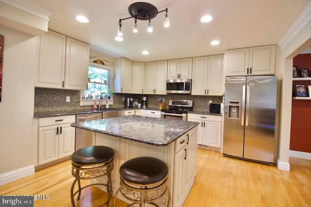 kitchen featuring light hardwood / wood-style flooring, tasteful backsplash, stainless steel appliances, and a kitchen island