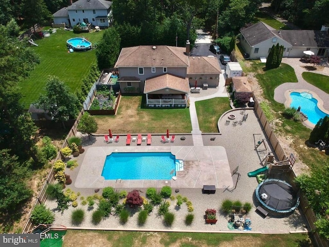 view of pool with a patio and a lawn