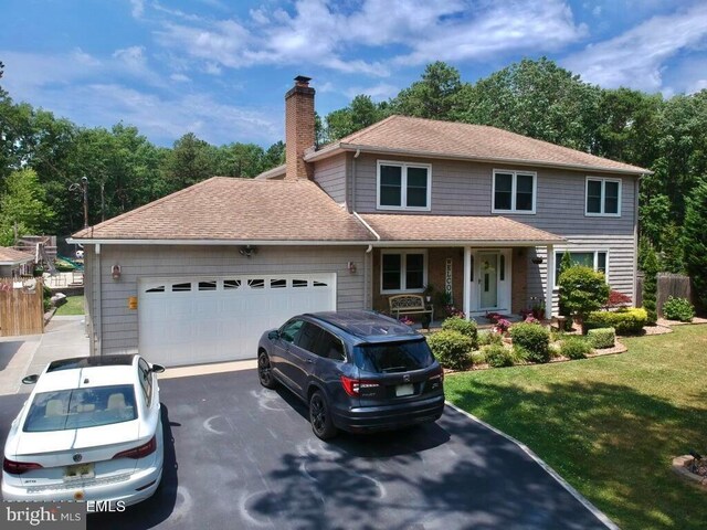 144 Sams Rd, Jackson, NJ 08527 - traditional-style house featuring an attached garage, covered porch, a chimney, a front yard, and driveway