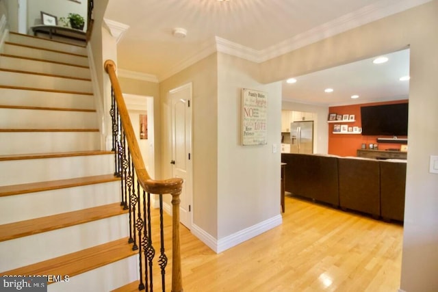 staircase featuring crown molding and hardwood / wood-style floors