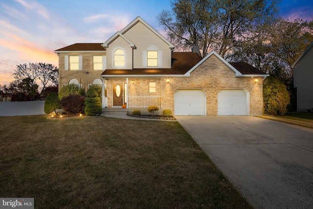 view of front of house featuring a lawn, covered porch, and a garage