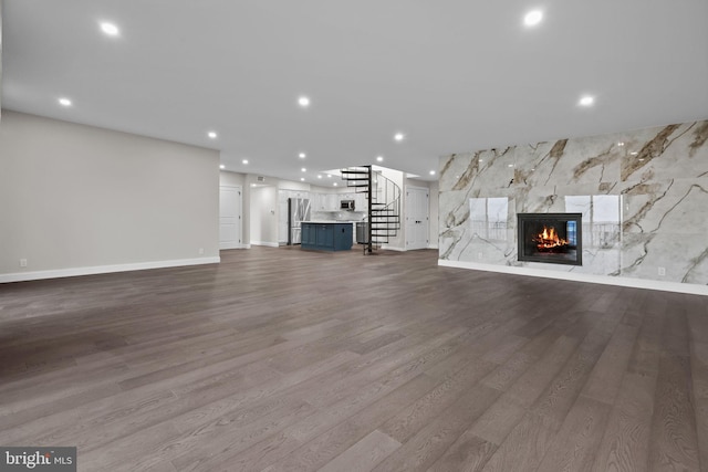 unfurnished living room featuring light hardwood / wood-style floors and a large fireplace