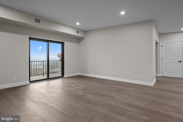 unfurnished room with hardwood / wood-style flooring