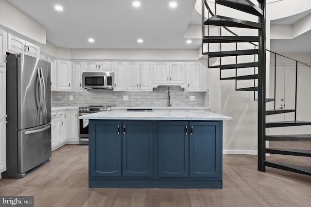 kitchen with white cabinetry, light wood-type flooring, appliances with stainless steel finishes, and a center island