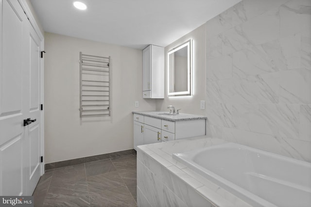 bathroom with vanity and a relaxing tiled tub