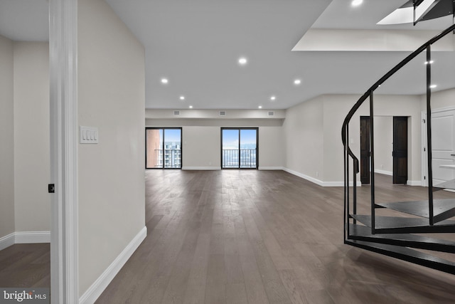 exercise area featuring dark hardwood / wood-style flooring and a skylight