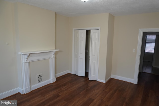 interior space featuring a closet, a textured ceiling, and dark hardwood / wood-style floors