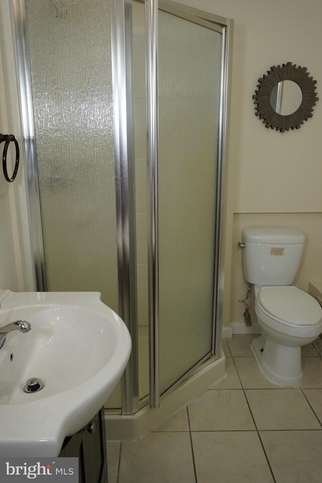 bathroom featuring a shower with door, toilet, tile patterned floors, and vanity