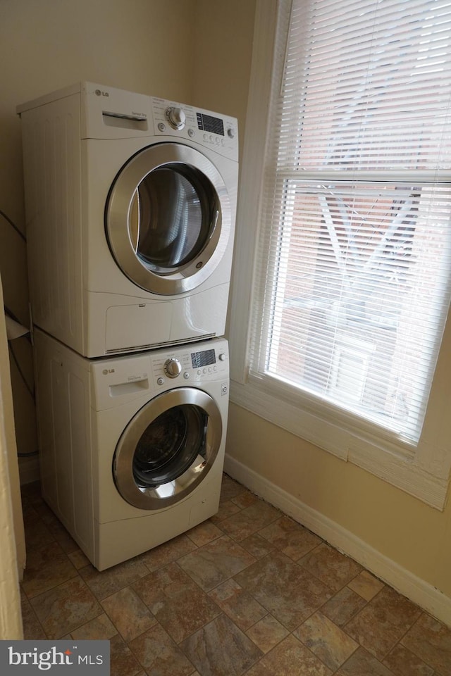 washroom featuring stacked washer and clothes dryer