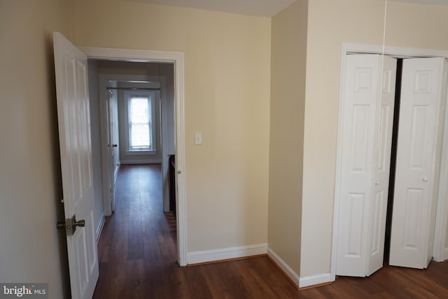 corridor with dark hardwood / wood-style flooring