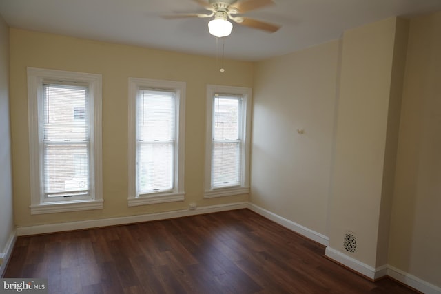 empty room featuring dark hardwood / wood-style floors, a healthy amount of sunlight, and ceiling fan