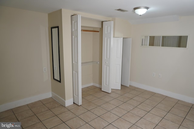 unfurnished bedroom featuring a closet and light tile patterned floors