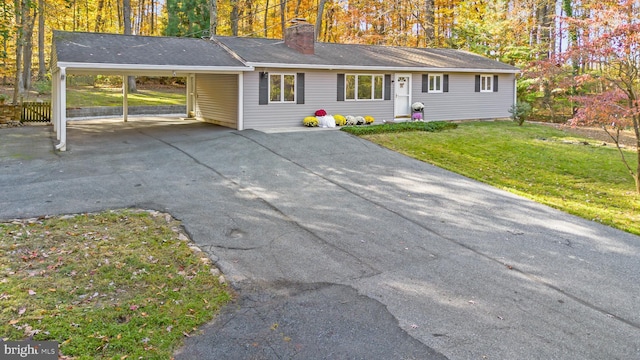 ranch-style house with driveway, an attached carport, a front lawn, and a chimney