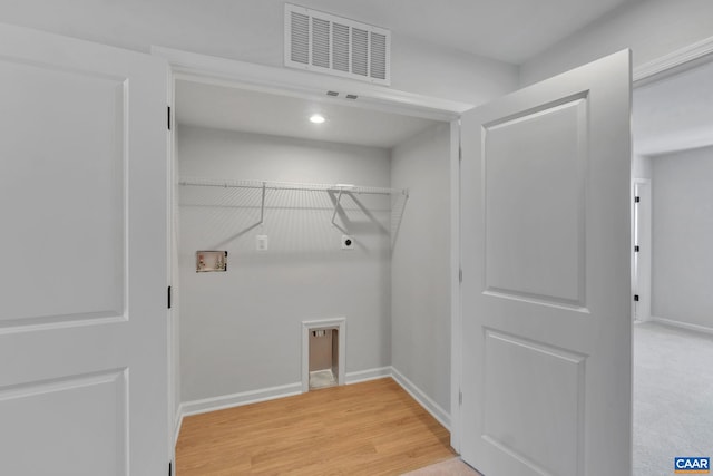 clothes washing area featuring electric dryer hookup, hardwood / wood-style flooring, and washer hookup