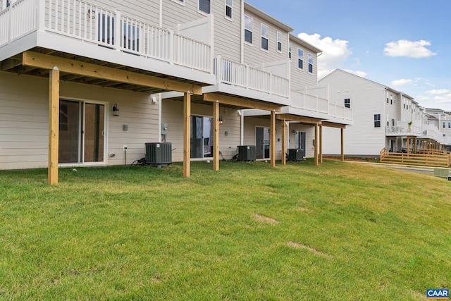 back of property with central air condition unit, a lawn, and a deck